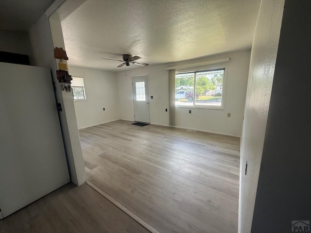 304 S Mullen, Lamar, CO 81052 - unfurnished living room with ceiling fan, wood finished floors, and a textured ceiling