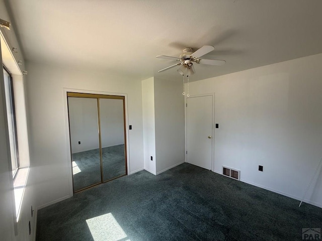 304 S Mullen, Lamar, CO 81052 - unfurnished bedroom featuring dark carpet, a closet, and a ceiling fan