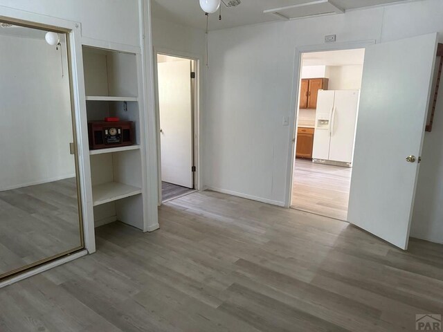 304 S Mullen, Lamar, CO 81052 - unfurnished bedroom featuring white refrigerator with ice dispenser, light wood-type flooring, and attic access