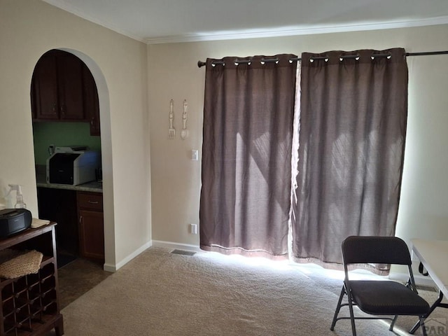 interior space with baseboards, visible vents, arched walkways, crown molding, and carpet flooring