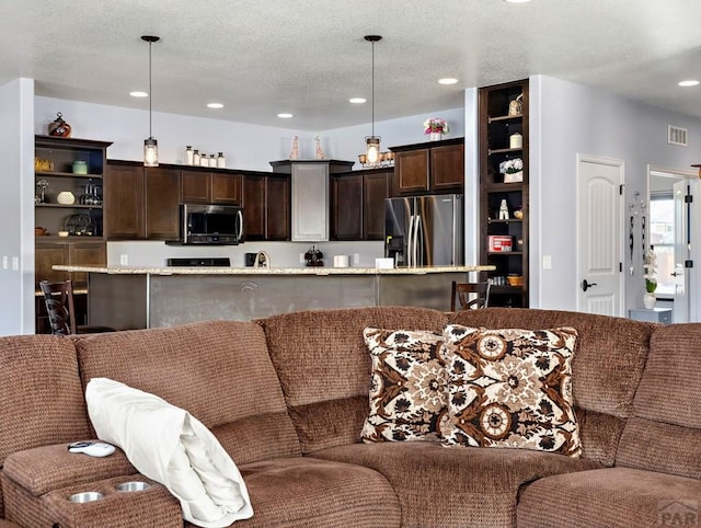 living area featuring recessed lighting, visible vents, and a textured ceiling