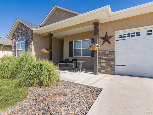 property entrance featuring a garage, stone siding, a porch, and stucco siding