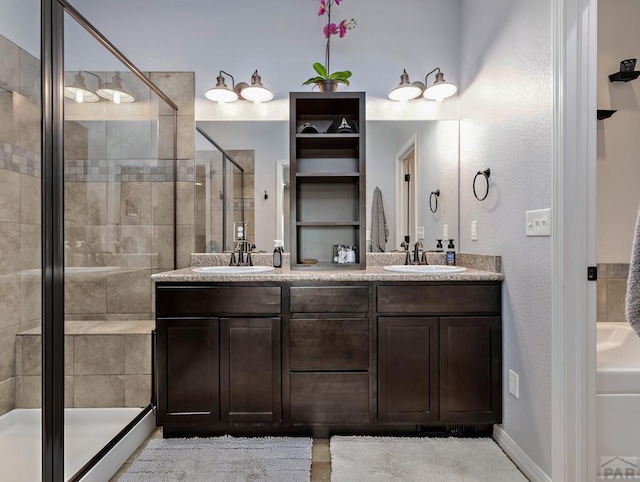 bathroom with a stall shower, a sink, baseboards, and double vanity