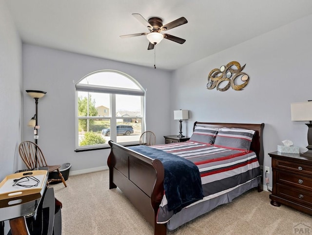 bedroom with baseboards, a ceiling fan, and light colored carpet