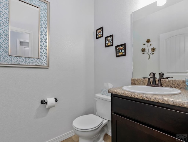 bathroom with toilet, baseboards, and vanity