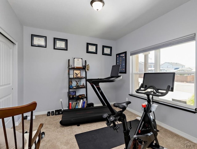 exercise room with carpet floors and baseboards