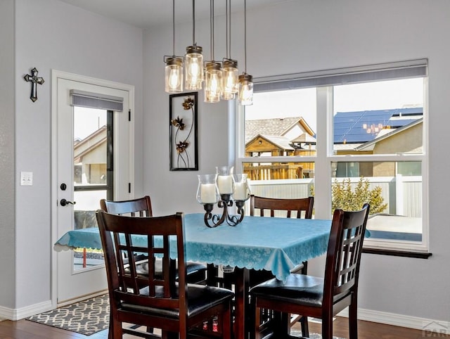 dining space with baseboards and dark wood-type flooring