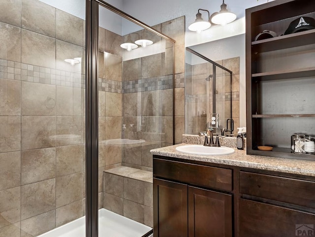 bathroom featuring a shower stall and vanity