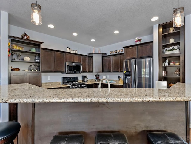 kitchen with stainless steel appliances, pendant lighting, dark brown cabinetry, and open shelves