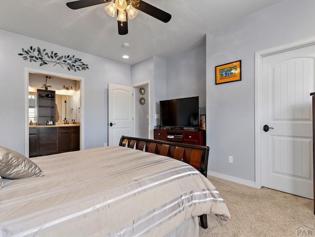 carpeted bedroom featuring baseboards, a ceiling fan, and ensuite bathroom