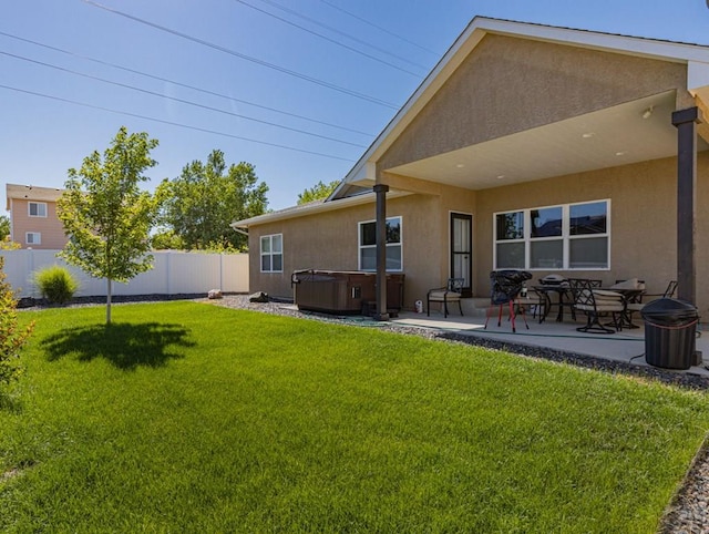 back of property featuring a patio area, a hot tub, a fenced backyard, and stucco siding