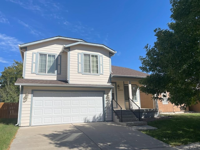 tri-level home featuring a garage, driveway, a shingled roof, and fence