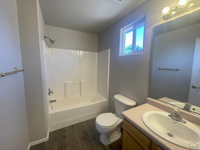 full bath featuring bathtub / shower combination, vanity, toilet, and wood finished floors