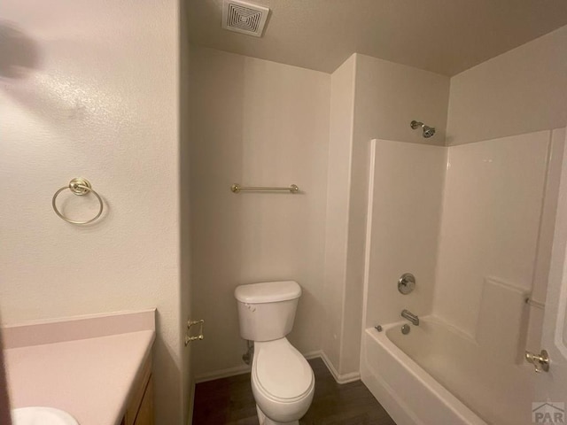 full bath featuring baseboards, visible vents, toilet, tub / shower combination, and vanity