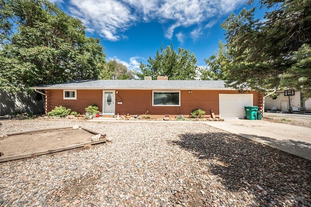 single story home with a garage, driveway, and a chimney