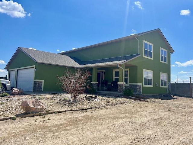 1507 N Gentry Ln, Pueblo West, CO 81007 - view of front of property with an attached garage, stone siding, stucco siding, a porch, and fence
