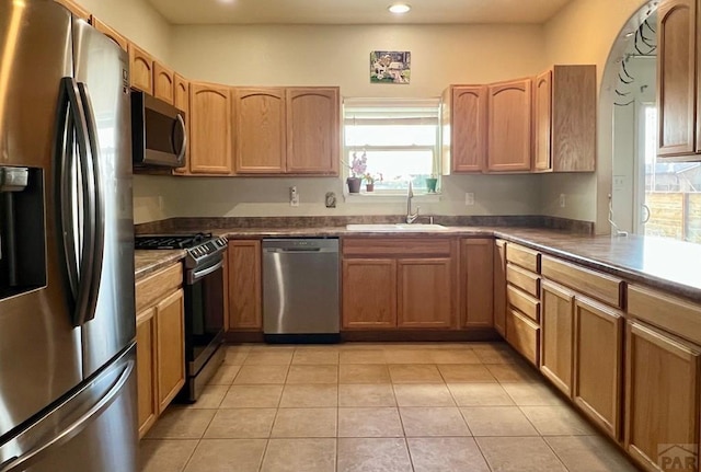 1507 N Gentry Ln, Pueblo West, CO 81007 - kitchen featuring appliances with stainless steel finishes, a sink, recessed lighting, light tile patterned flooring, and dark countertops