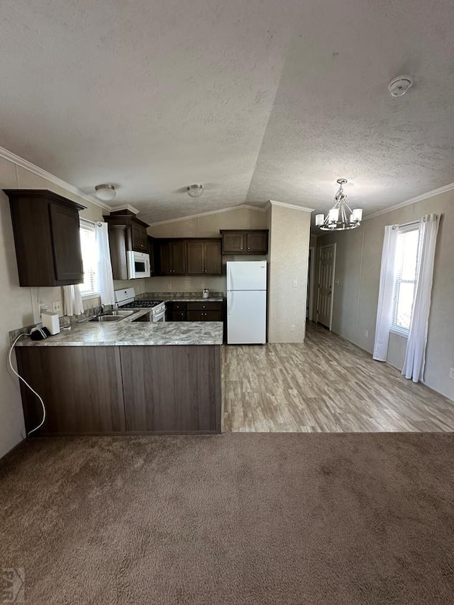 kitchen featuring a peninsula, white appliances, light countertops, ornamental molding, and dark brown cabinets