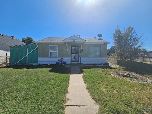 bungalow-style home with fence and a front lawn