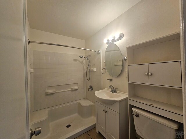 bathroom with toilet, walk in shower, vanity, and tile patterned floors