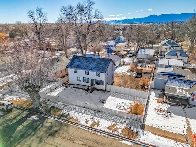 snowy aerial view with a mountain view and a residential view