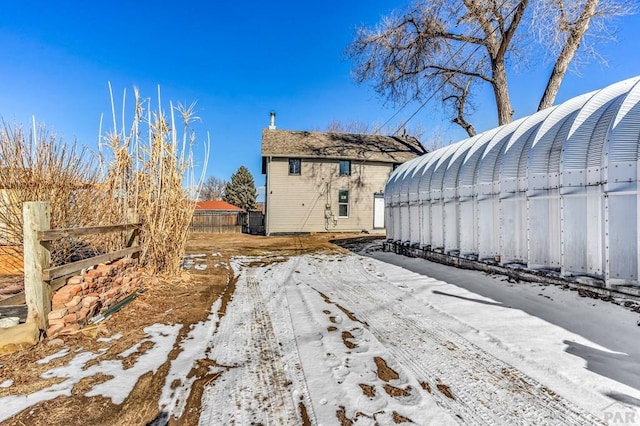 view of snowy exterior with fence