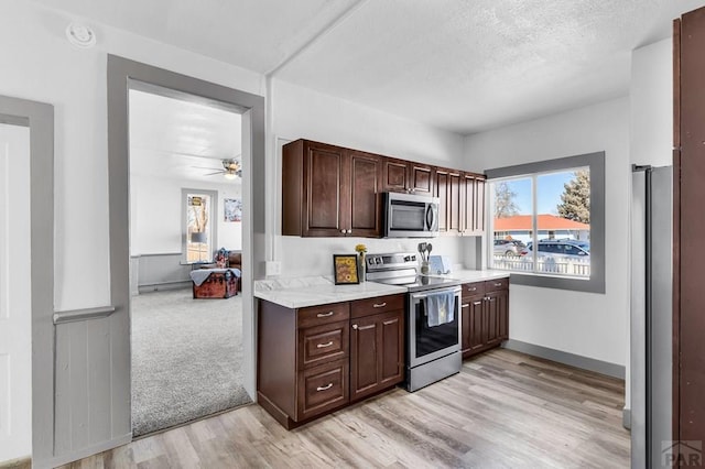 kitchen with plenty of natural light, light countertops, light wood-style floors, and stainless steel appliances