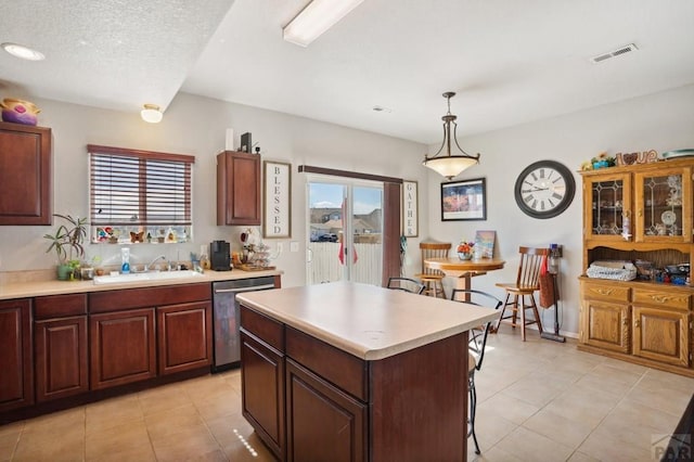 5073 Buchanan Dr, Pueblo, CO 81008 - kitchen featuring dishwasher, light countertops, light tile patterned flooring, a kitchen breakfast bar, and a kitchen island