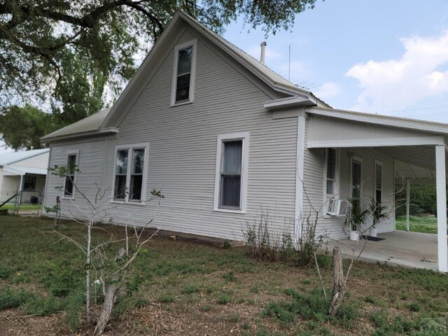 view of home's exterior featuring cooling unit, a carport, and a yard