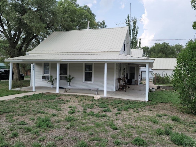 view of front of home with metal roof, a porch, and cooling unit