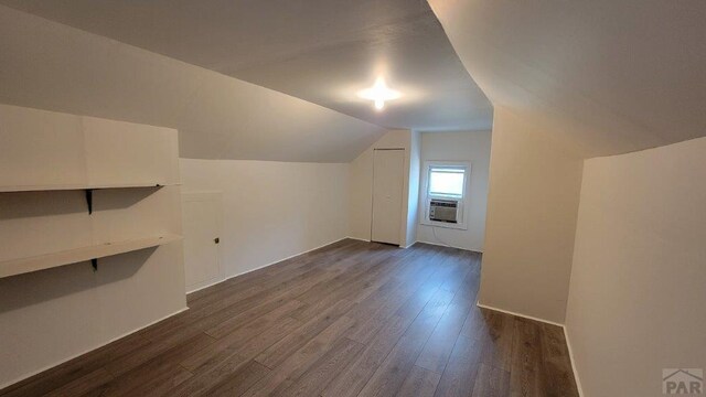 bonus room with lofted ceiling and dark wood-type flooring