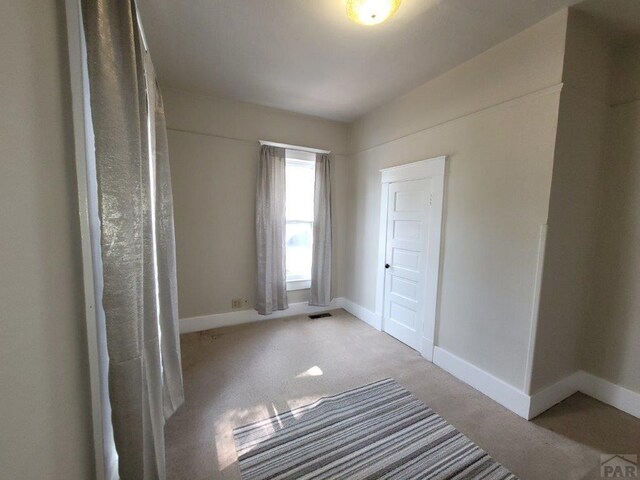 interior space featuring light carpet and baseboards