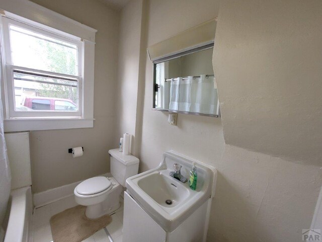 full bathroom with baseboards, a sink, toilet, and tile patterned floors