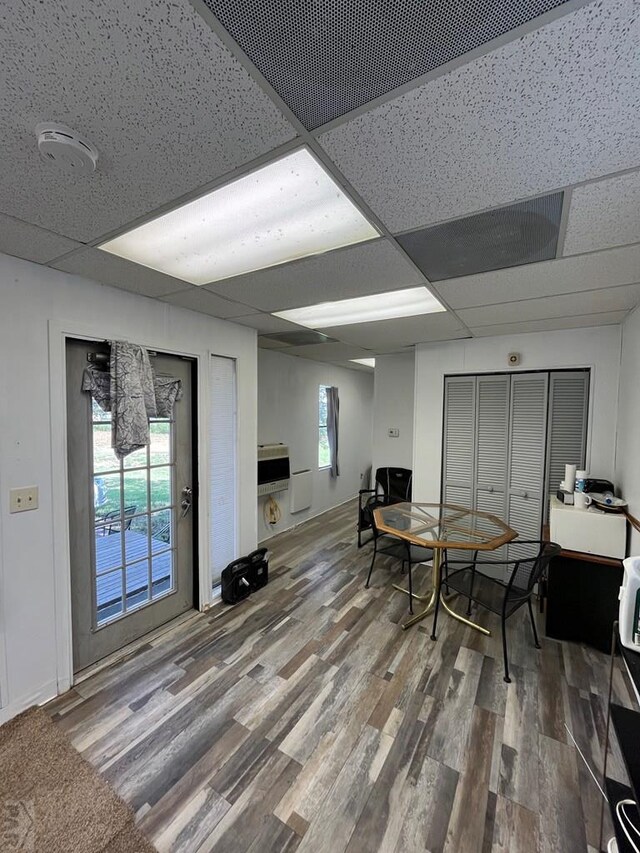 interior space with a drop ceiling and wood finished floors