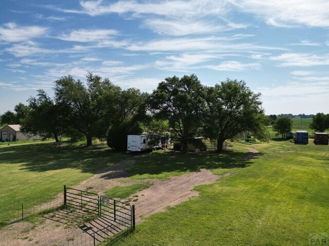 surrounding community with a yard, fence, and a rural view