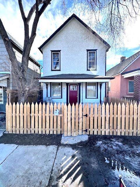 view of front facade featuring a fenced front yard and stucco siding