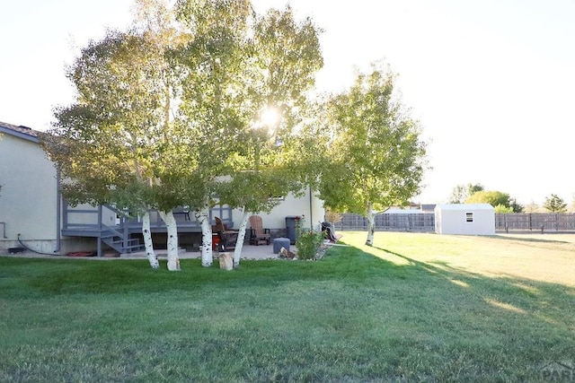 view of yard with a shed, an outdoor structure, and fence