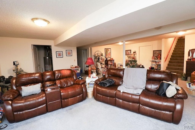 carpeted living room with water heater, stairway, and a textured ceiling