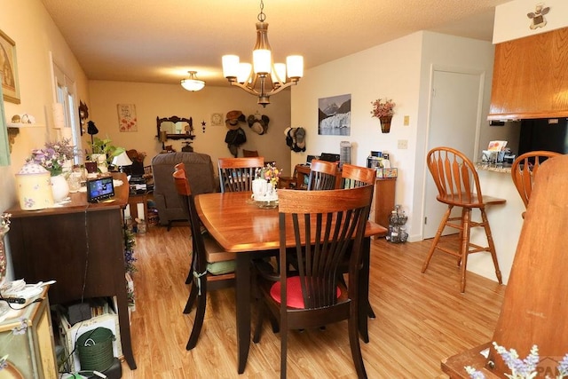 dining space with light wood-type flooring and a chandelier