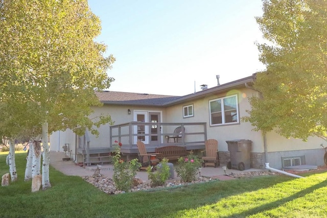 back of house with a patio area, a lawn, and stucco siding