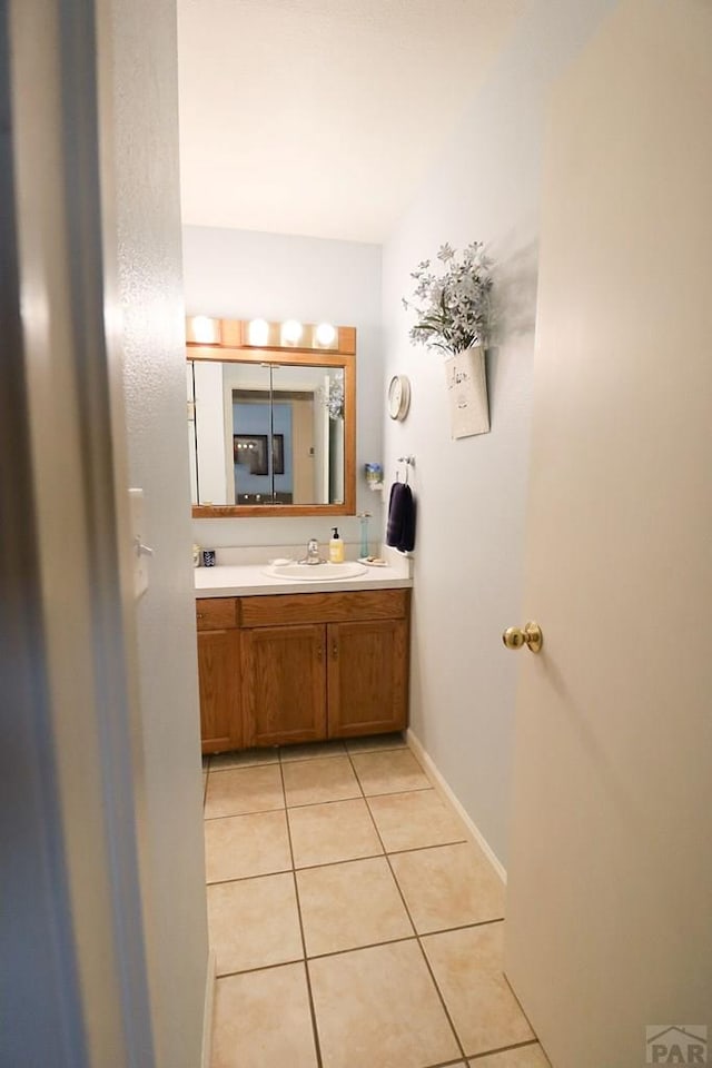 bathroom with vanity, baseboards, and tile patterned floors