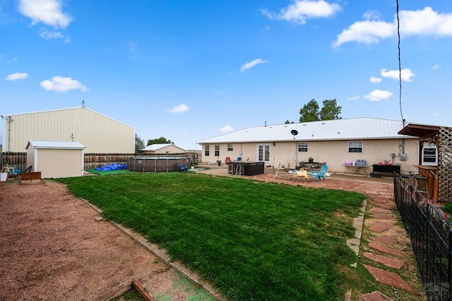 back of house with a fenced in pool, a storage unit, a patio area, a fenced backyard, and an outdoor structure