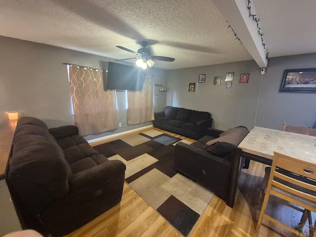 living area featuring ceiling fan, a textured ceiling, and wood finished floors