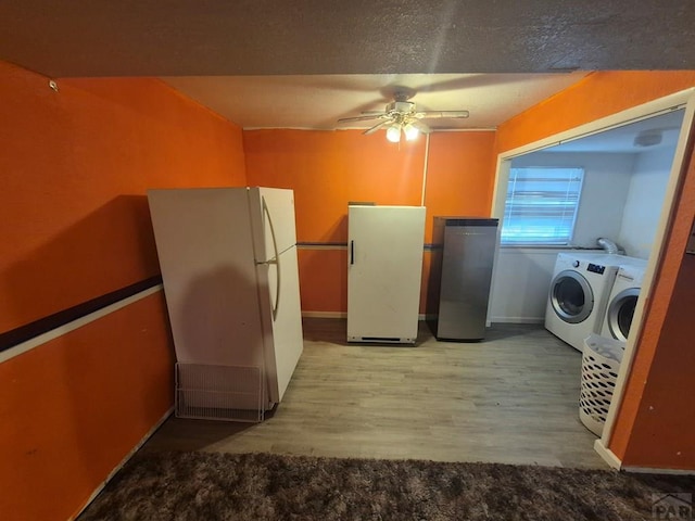 kitchen featuring fridge, independent washer and dryer, wood finished floors, and freestanding refrigerator