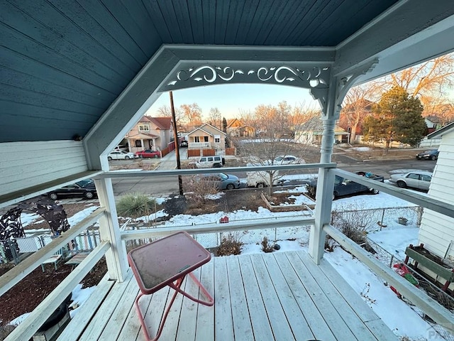 snow covered deck with a residential view and covered porch