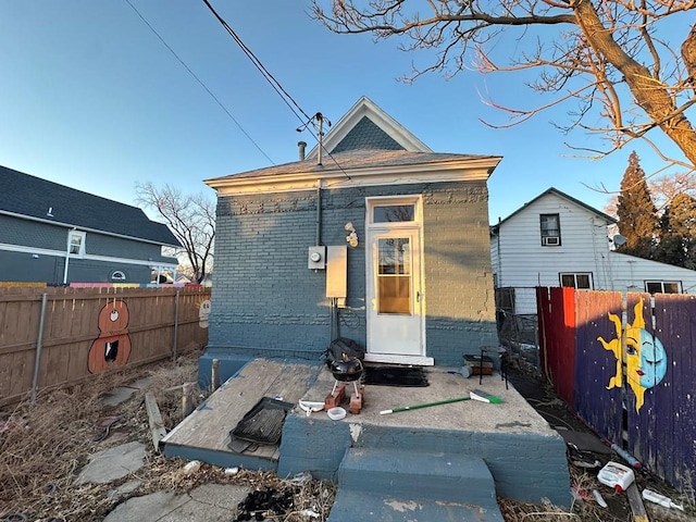 exterior space featuring entry steps, brick siding, and a fenced backyard