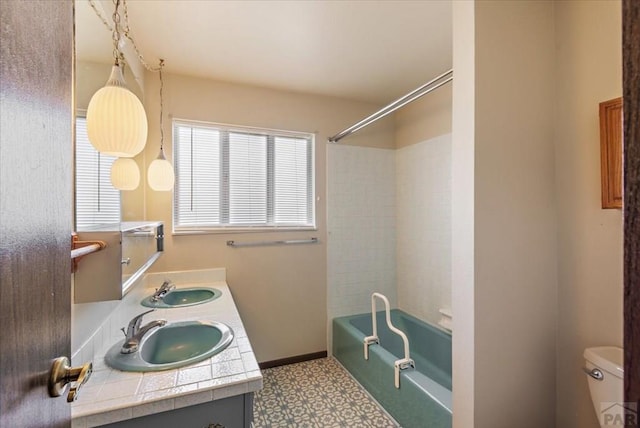 full bath featuring a sink, toilet, tile patterned floors, and shower / tub combination