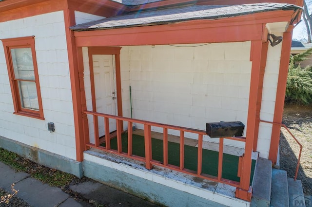 property entrance featuring a shingled roof