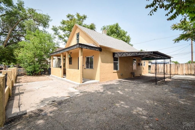 1232 Spruce St, Pueblo, CO 81004 - back of property with stucco siding, an attached carport, and roof with shingles
