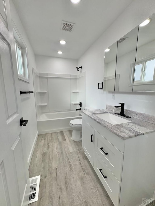 full bathroom featuring visible vents, shower / bathing tub combination, toilet, and wood finished floors